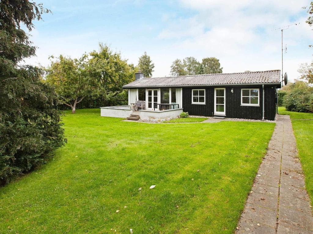 a black house with a large yard in front of it at 4 star holiday home in Dronningmølle in Dronningmølle