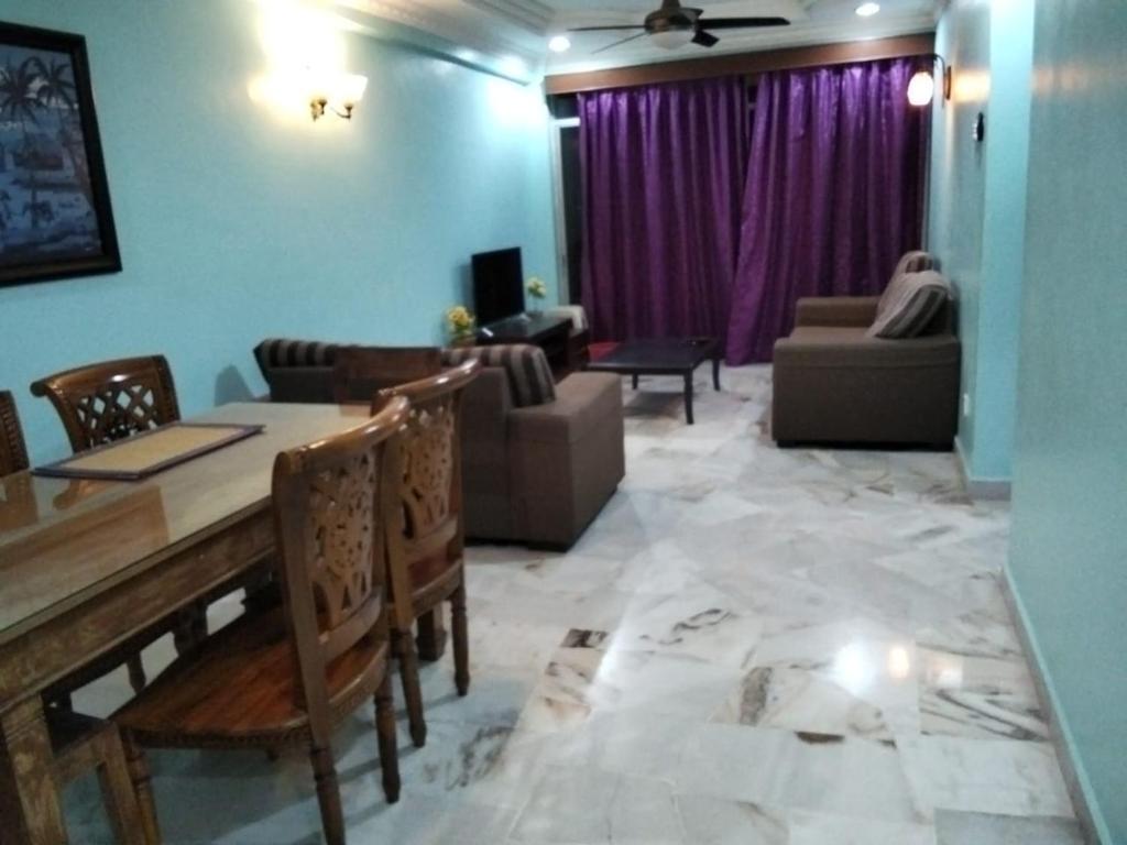 ein Wohnzimmer mit Tisch und Stühlen und einer Couch in der Unterkunft Glory Beach Resort SEAVIEW in Port Dickson