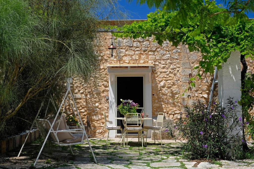 a table and chairs in front of a stone building at Masseria Pagliamonte Ortensia in San Vito dei Normanni