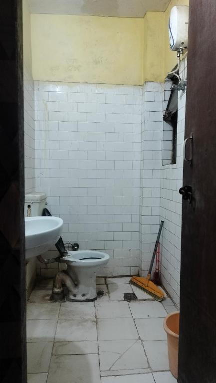 ein schmutziges Badezimmer mit Toilette und Waschbecken in der Unterkunft Raghunath bhawan in Haridwar