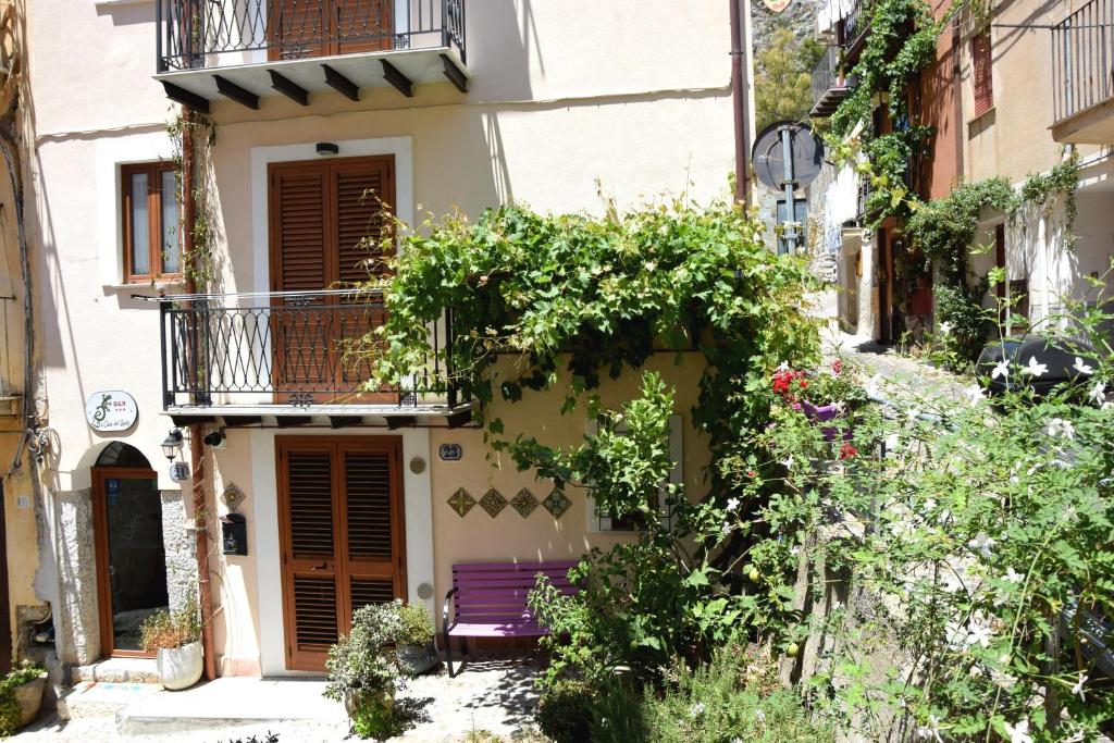 a building with a purple bench in front of it at La Casa del Geko in Cefalù