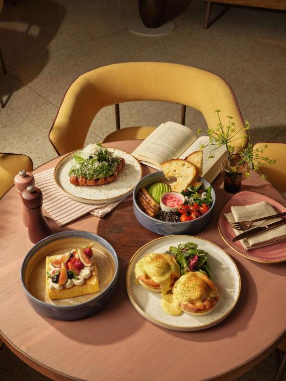 A styled breakfast table with eggs, toast, salad and fruit dishes.