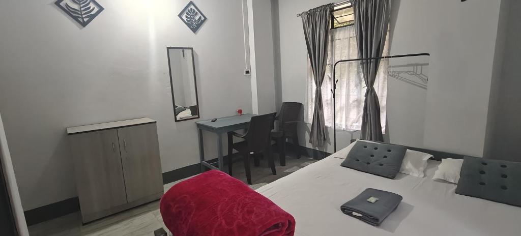 a bedroom with a bed with a red pillow on it at Harry's Homestay in Shillong