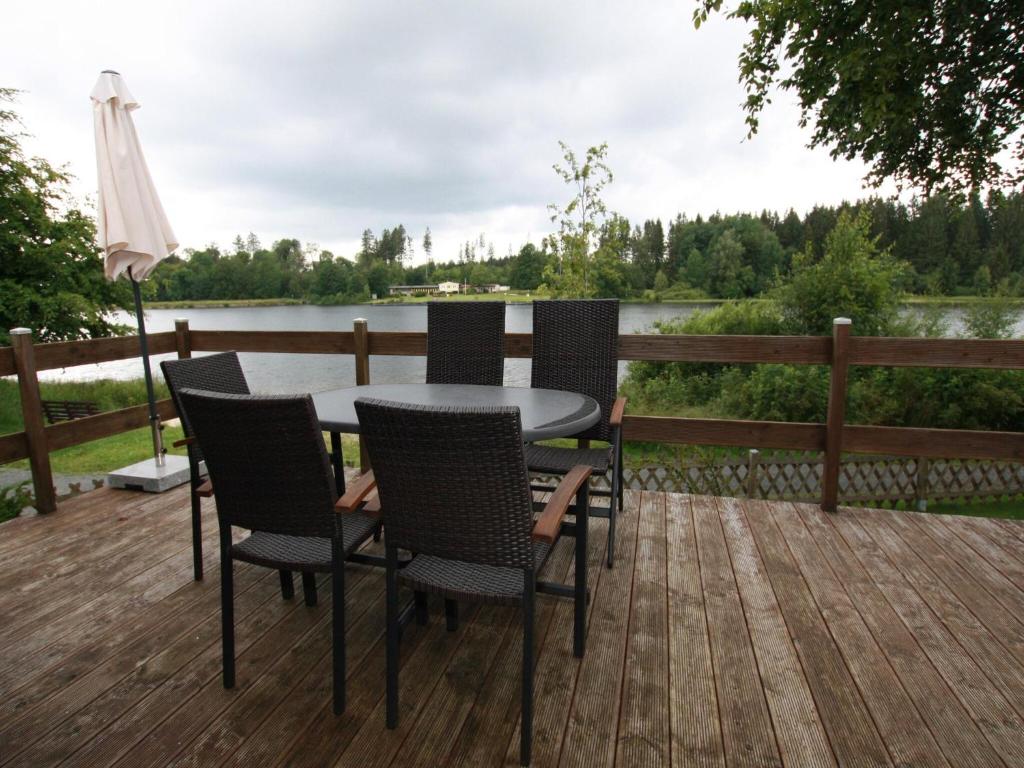 a table and chairs on a deck with a view of a lake at Ferienhaus mit Terrasse, Haustierfrei in Clausthal-Zellerfeld