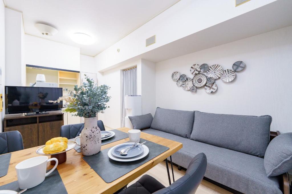 a living room with a couch and a table at 栄エリア徒歩圏の好立地 栄まで1駅 名古屋駅まで乗換不要 地下鉄最寄り駅徒歩9分 最大5名 in Nagoya