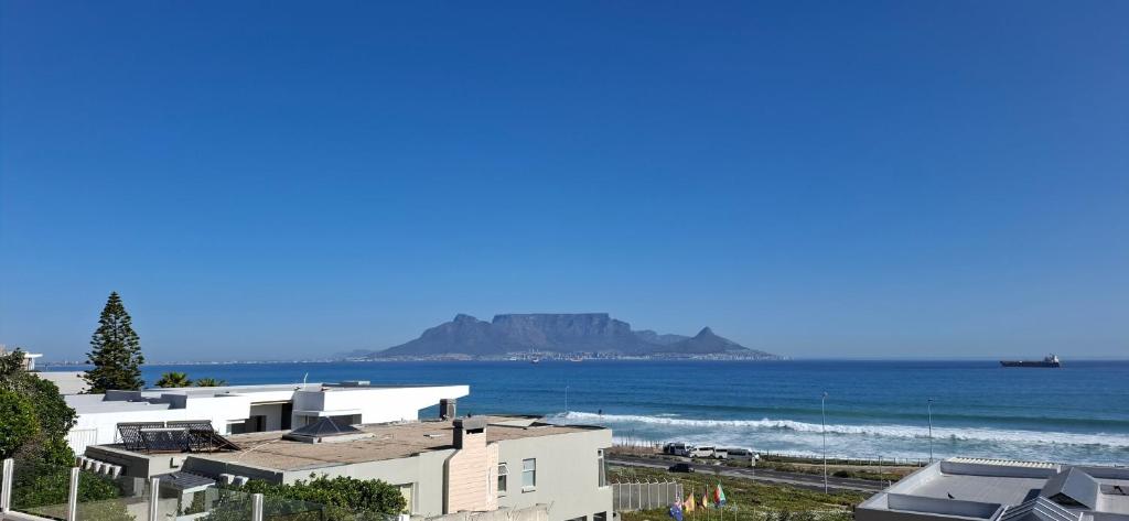 Una vista de la playa con casas y el océano. en 2WhiteWaters Bloubergstrand Homestay, en Bloubergstrand