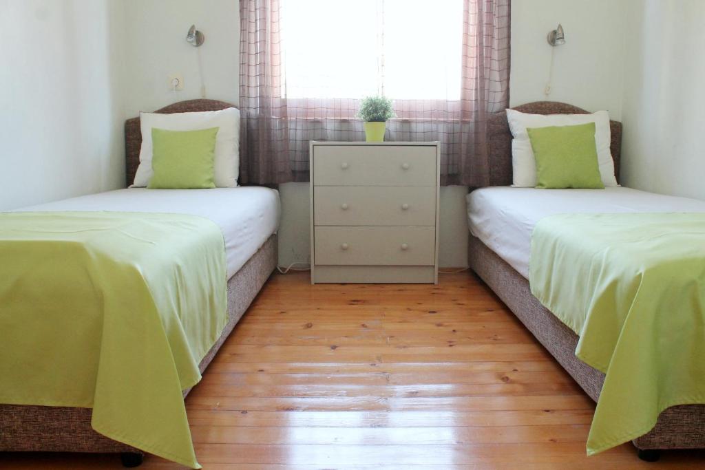 two twin beds in a room with wooden floors at Apartments Villa Milna 1 in Budva