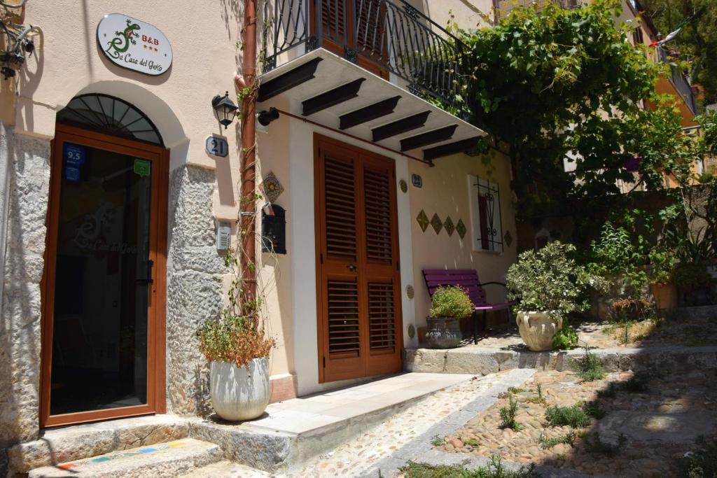 a building with a wooden door and a balcony at La Casa del Geko in Cefalù