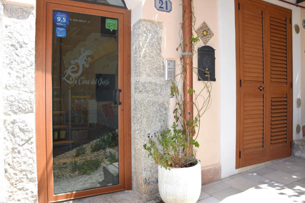 a building with a door and a plant in front of it at La Casa del Geko in Cefalù