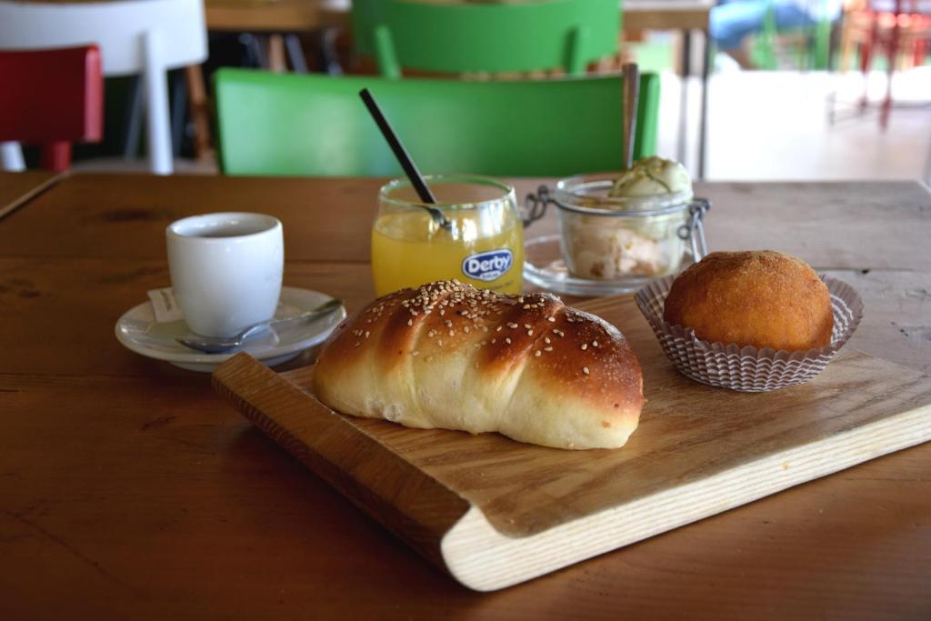 a table with a cutting board with a loaf of bread and a muffin at La Casa del Geko in Cefalù