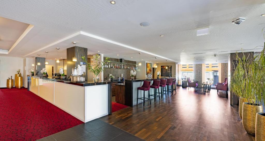 a bar in a restaurant with a red carpet at PLAZA Premium Salzburg in Salzburg