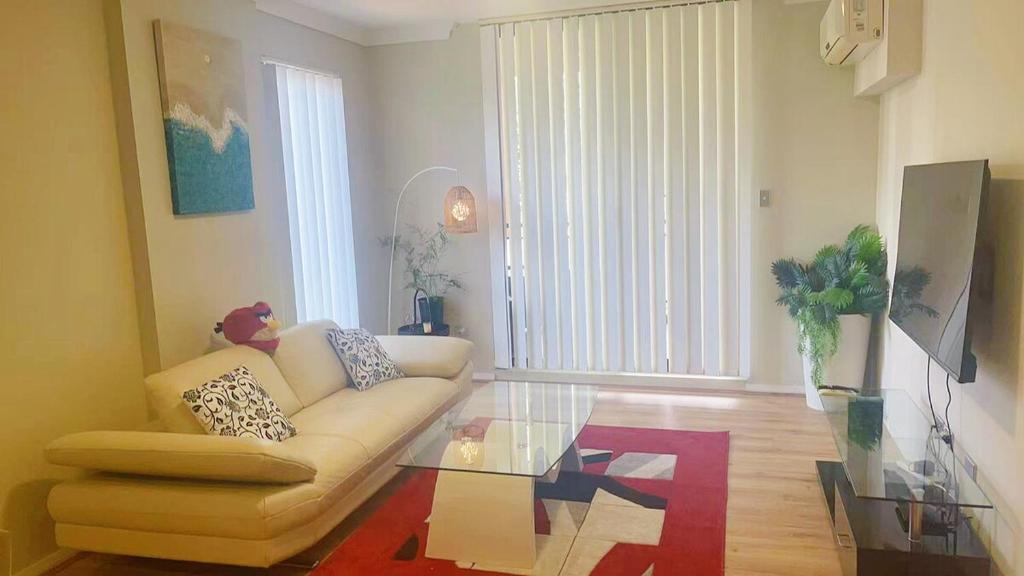 a living room with a couch and a glass table at Norwest business park in Baulkham Hills