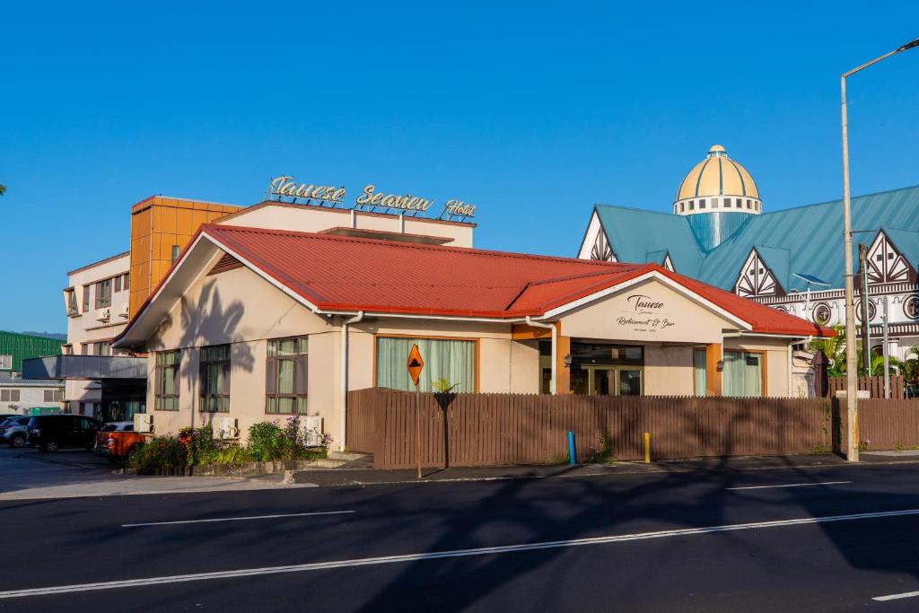 a building with a red roof on a street at Tauese Seaview Hotel in Apia