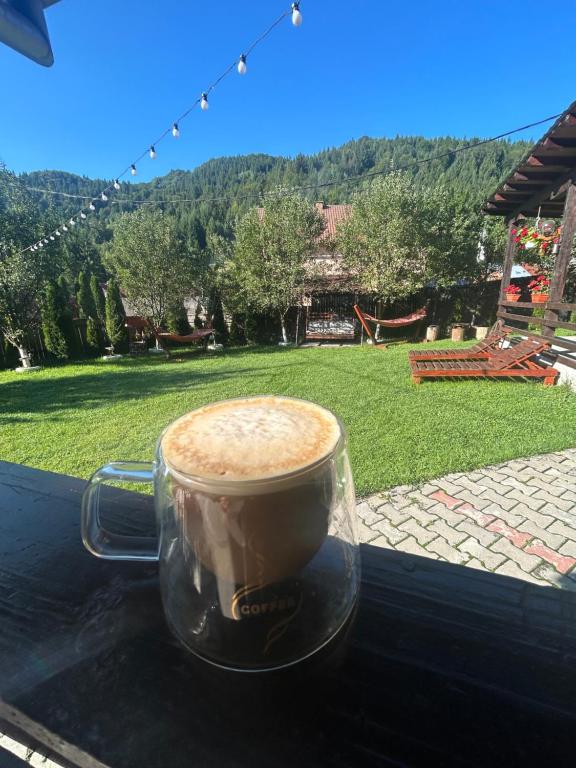 a cup of coffee sitting on top of a table at Cabana Ana in Vadu Moţilor
