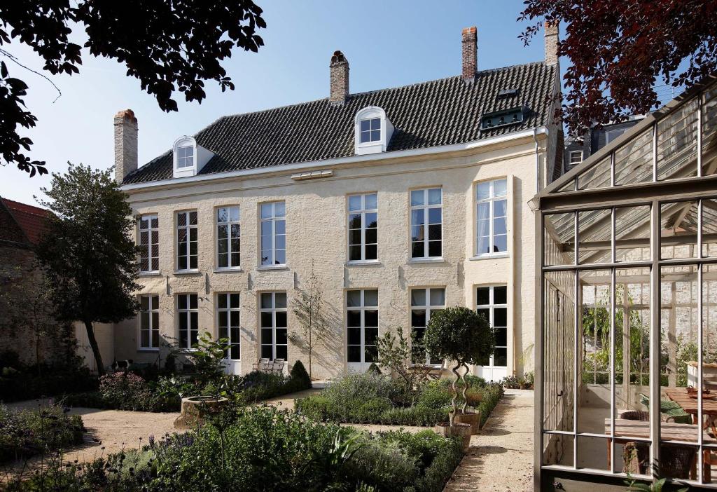 an exterior view of a large house with a garden at B&B De Corenbloem Luxury Guesthouse - Adults Only in Bruges