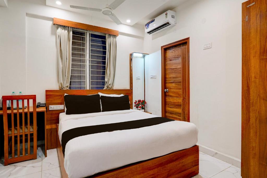 a bedroom with a bed and a desk and a window at Super Townhouse Marathahalli KLM Fashion Mall Formerly Hotel Avenue in Bengaluru