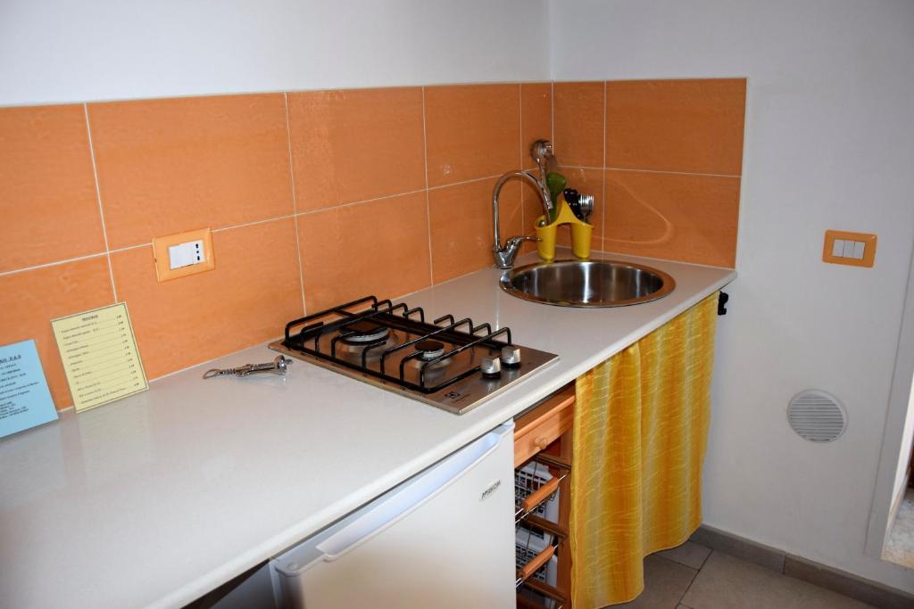 a small kitchen with a sink and a stove at La Casa del Geko in Cefalù