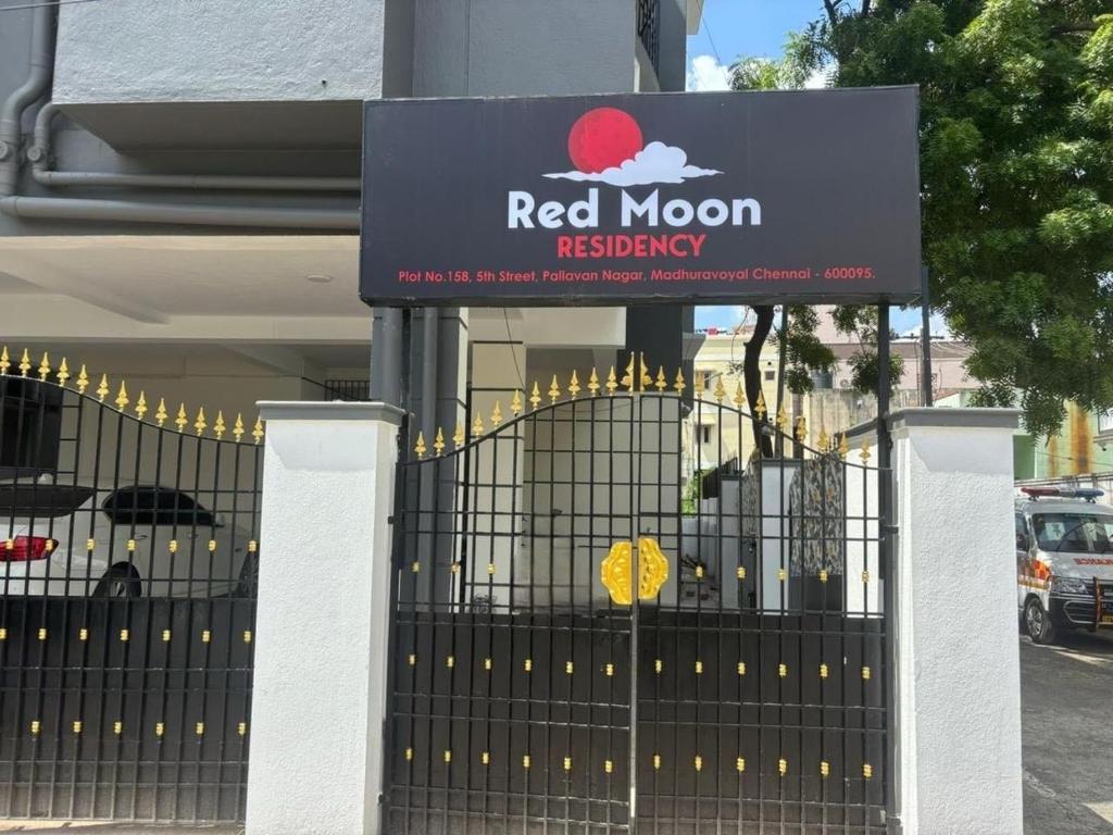 Un cartel de registro de luna roja en una puerta frente a un edificio en Super Hotel O Red Moon Residency, en Chennai