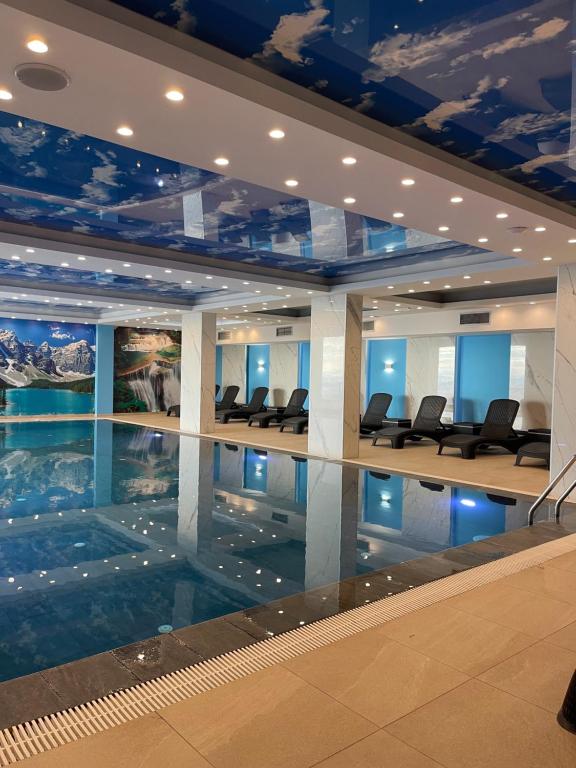 a large swimming pool in a building with chairs at Evergreen Lux in Kopaonik