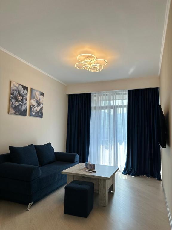 a living room with a blue couch and a table at Alvina complex Vakas Tsakghadzor apartament in Tsaghkadzor