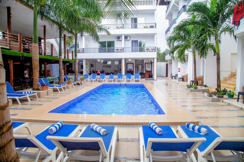 Una piscina en el hotel con sillas y palmeras. en Golden Hotel, en Nungwi