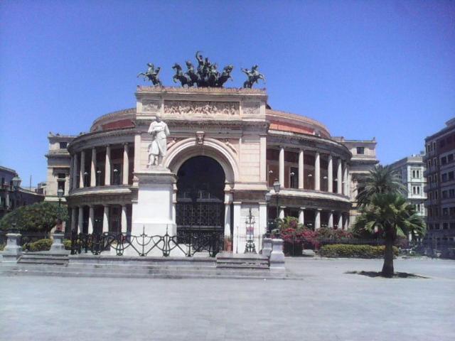 un gran edificio con una estatua delante de él en Palermo Centrale, en Palermo