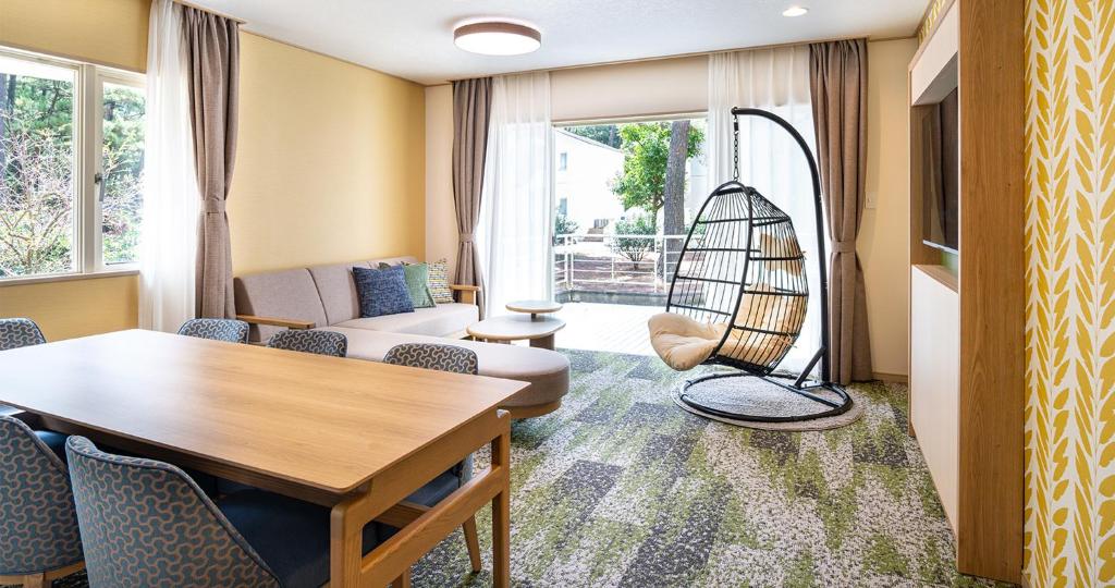 ein Wohnzimmer mit Tisch und Stühlen in der Unterkunft Seagaia Forest Cottages in Miyazaki