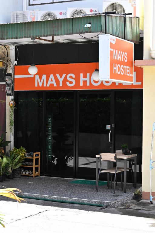 华欣Mays Hostel的一栋带有梅尼斯医院标志的建筑