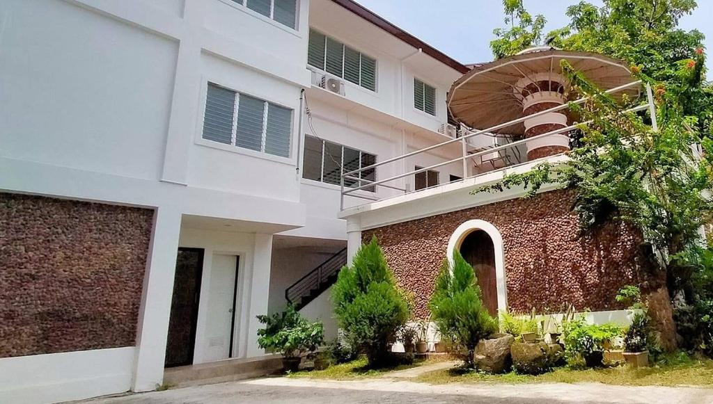 Un edificio blanco y rojo con una pared de ladrillos. en DDD Habitat Inc Iloilo, en Iloilo City