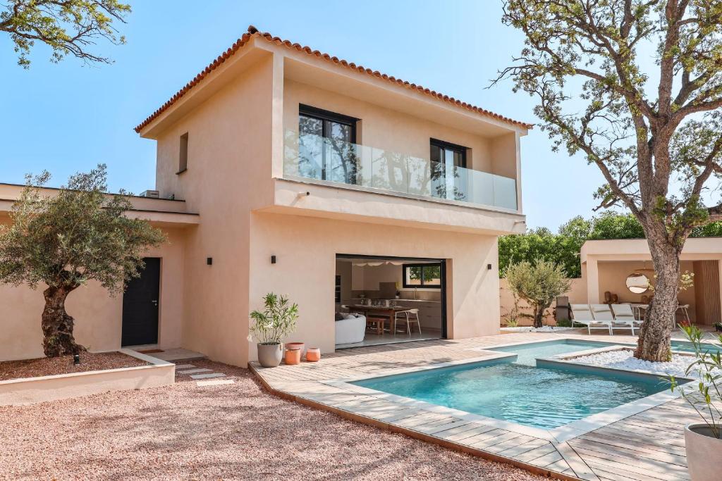 una villa con piscina frente a una casa en Villa Luciana Di Santa Lucia, en Sainte-Lucie de Porto-Vecchio