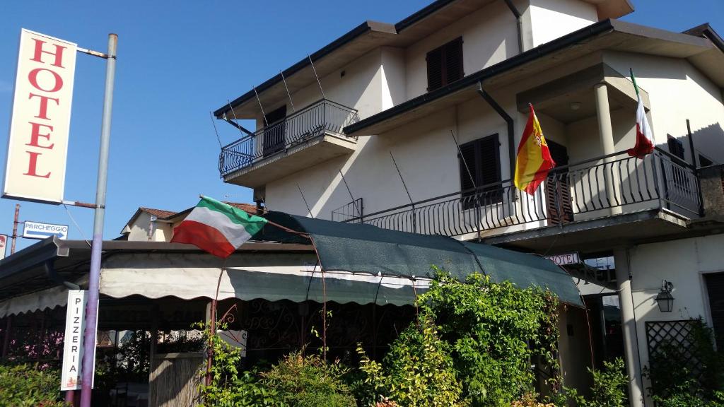 ボルゴ・ア・ブッジャーノにあるHotel Tarabarallaの旗の横に二本の建物