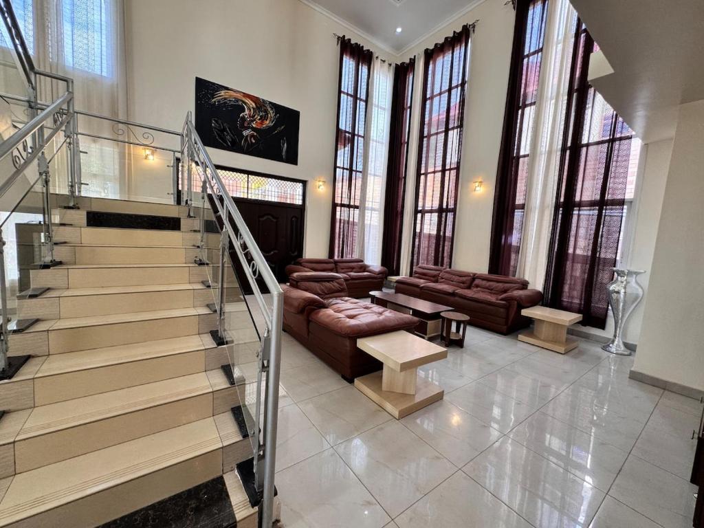 a living room with a staircase with a couch and a table at Family Corner Suite by Iwacu Stays in Kigali