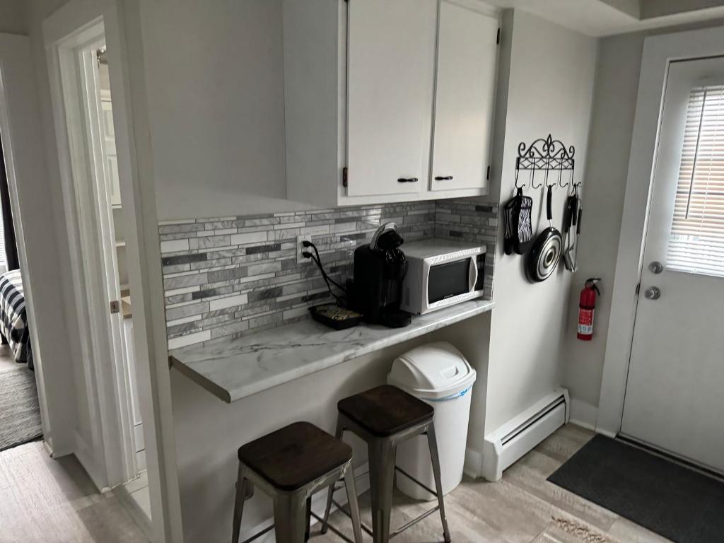 a kitchen with a counter with a microwave and two stools at Gem 1 Downtown Willoughby Historic District in Willoughby