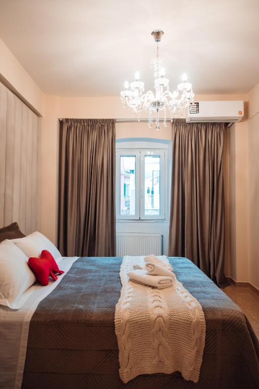 a bedroom with a large bed and a chandelier at Luxury Suite Prada in Paleokastritsa