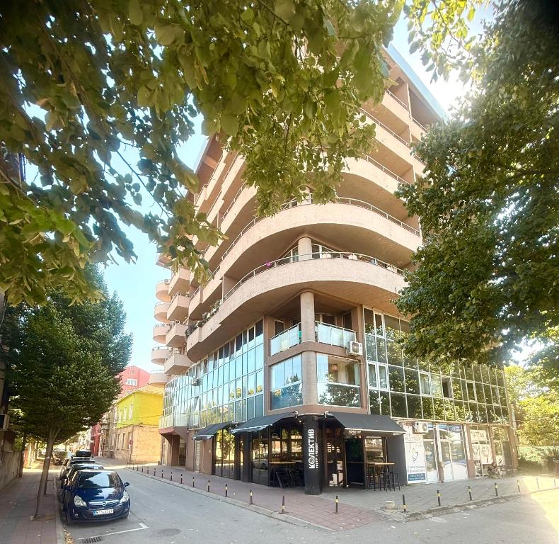 a building with a car parked in front of it at Natalie Apartment in Niš
