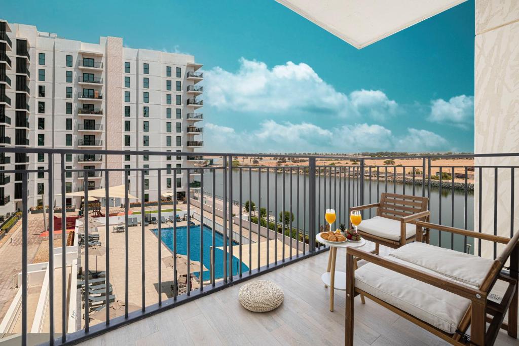 a balcony with a view of a pool and buildings at DVH Luxe Retreats 2BR Yas Island by Ferrari World & Yas Mall in Abu Dhabi