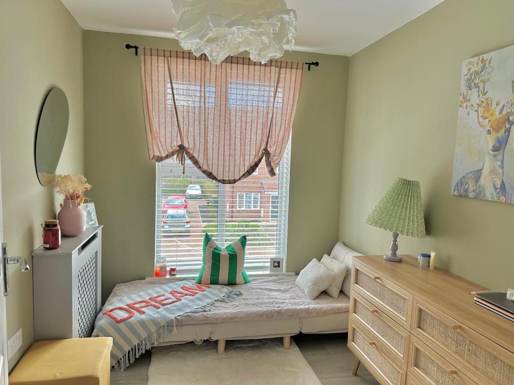 Un dormitorio pequeño con una cama y una ventana. en Pink Paradise, en Dunstable