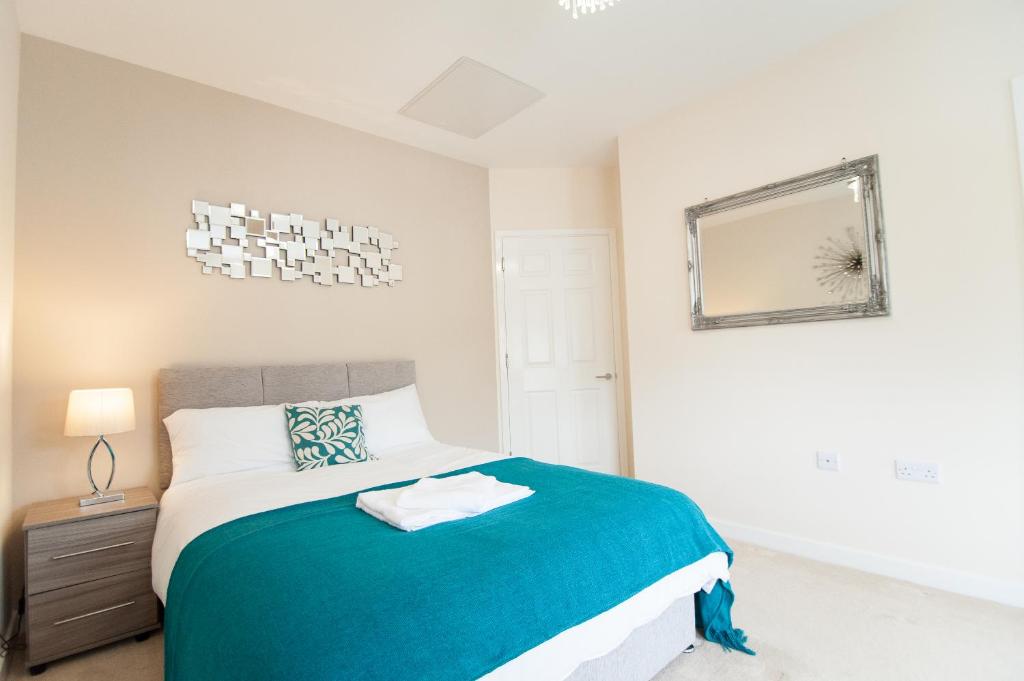 a bedroom with a bed and a mirror on the wall at Station Suites in Watford