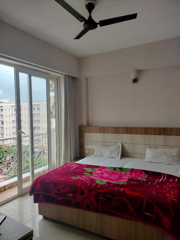 Un dormitorio con una cama y una ventana grande. en Eternity Grand Vrindavan, en Chhatikara