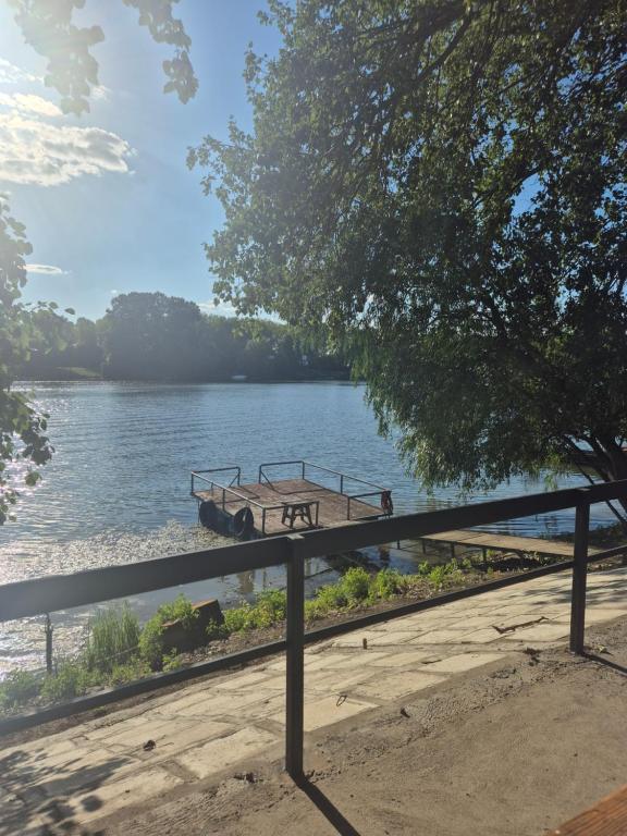 a boat sitting on the side of a river at Vikendica na Tisi in Ada