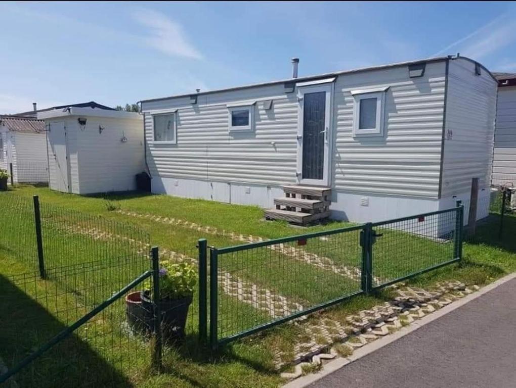 a tiny house in a yard with a fence at Les Tournesols in Middelkerke