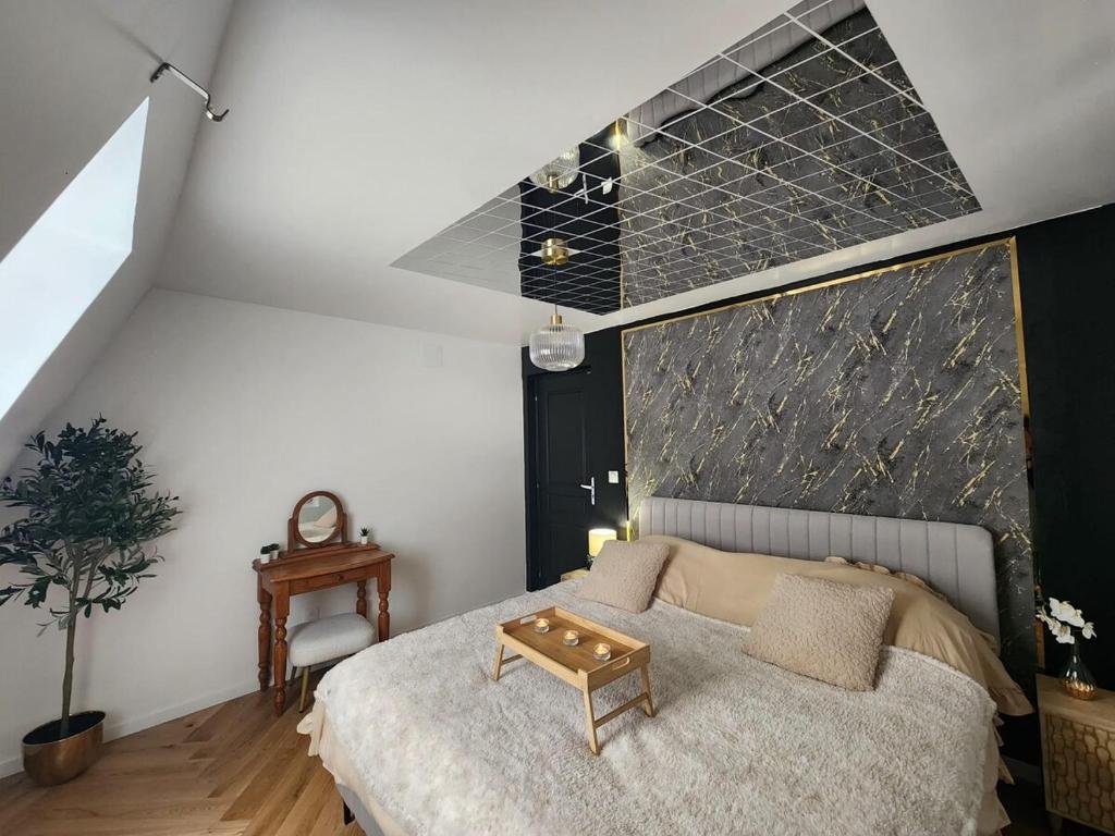 a bedroom with a bed with a table on it at Suite Secrète in Sélestat