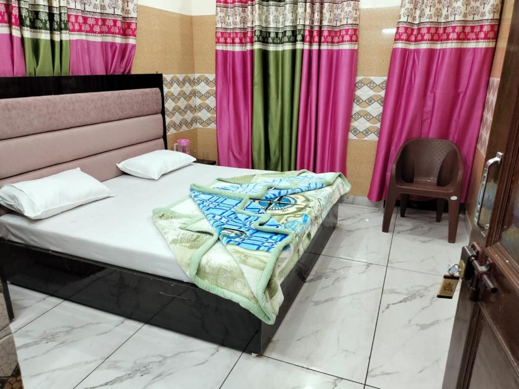 a bed in a room with pink and green curtains at Shumba home stay in Udhampur