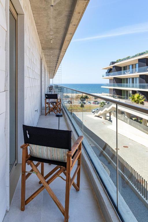 a bench on a balcony with a view of the ocean at Ocean Living by MP in Vila Nova de Gaia