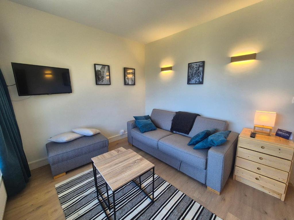 a living room with a couch and a table at Appartement lumineux skis aux pieds avec balcon - FR-1-502-541 in Tignes