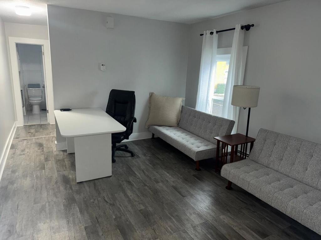 a living room with a couch and a desk and a table at Downtown Willoughby historical district Gem 4 in Willoughby