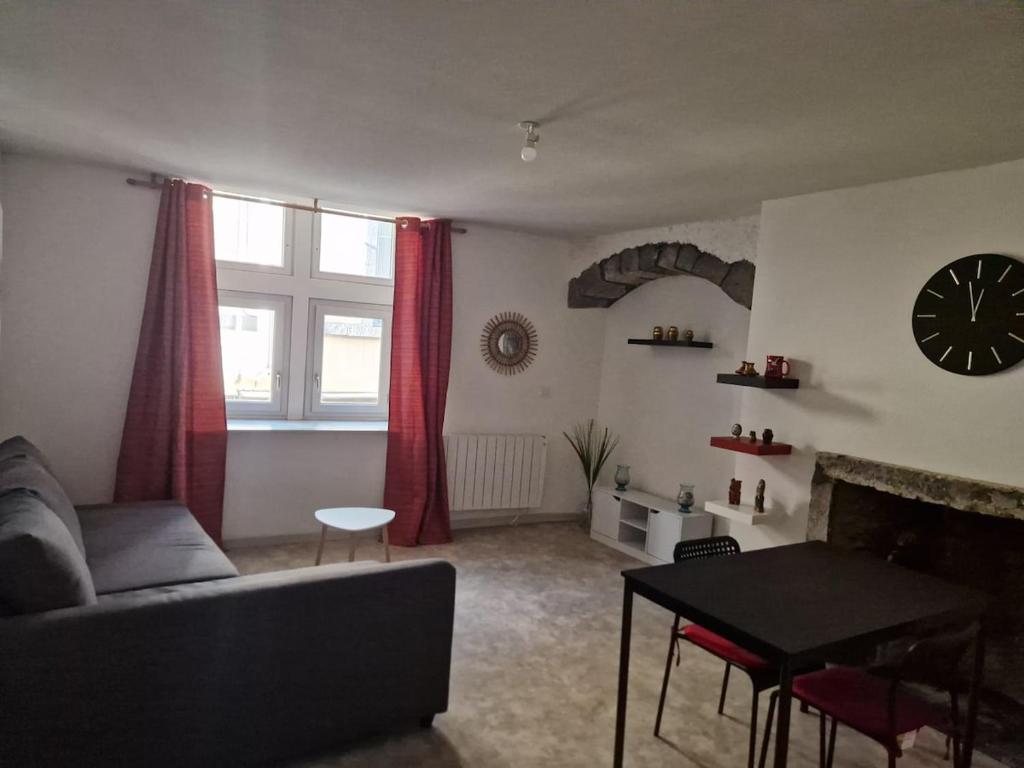 sala de estar con sofá, mesa y reloj en Studio Angela, en Riom