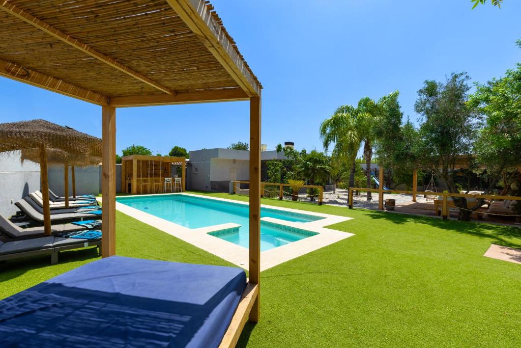 a backyard with a swimming pool and green grass at WaterWheel by Fidalsa in El Camino de Catral