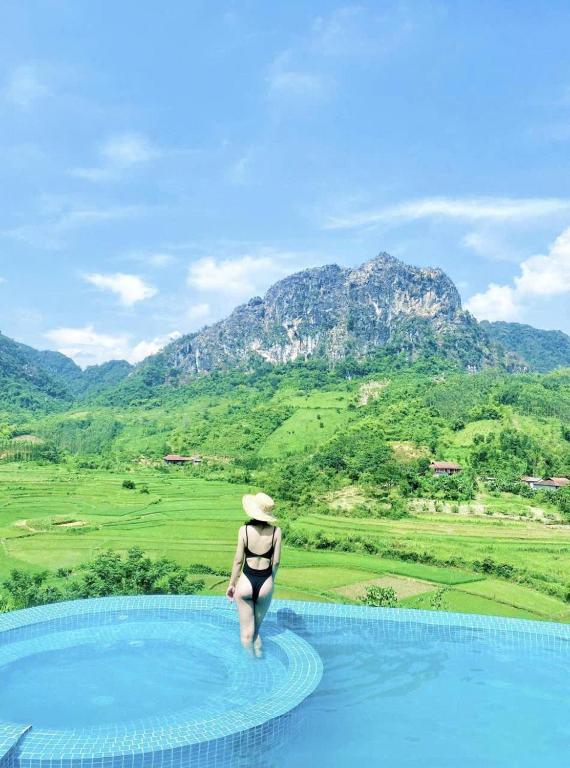 a woman in a hat standing on top of a swimming pool at Bamboo Hill Resort in Hữu Lũng