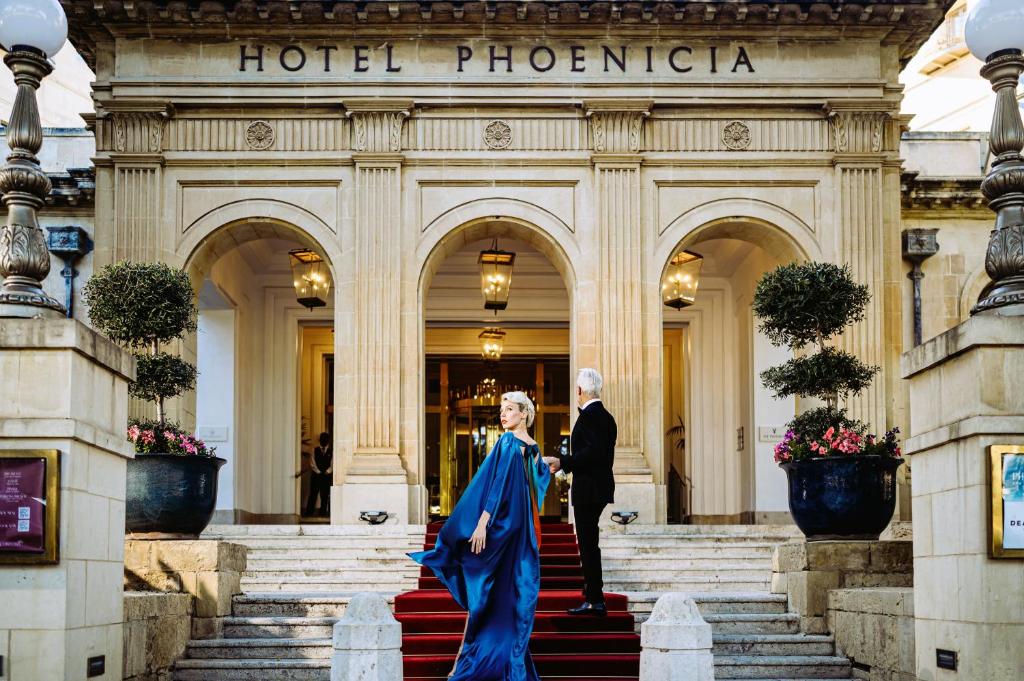 バレッタにあるThe Phoenicia Malta - The Leading Hotels of the Worldのフェニックスホテルの階段を下りる男女